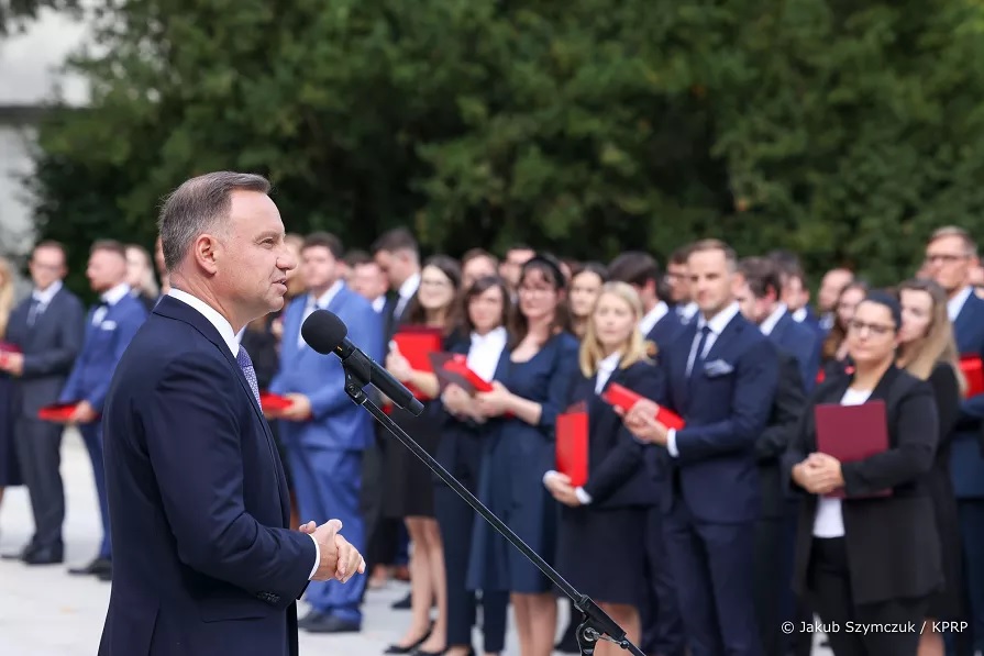 mężczyzna (Prezydent RP Andrzej Duda) przemawia przez mikrofon do grupy osób
