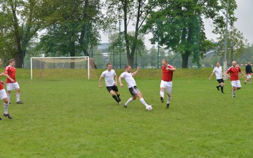 Zdjęcie nr 12: ośmiu mężczyzn na boisku piłkarskim biegnących za piłką w czasie meczu piłki nożnej