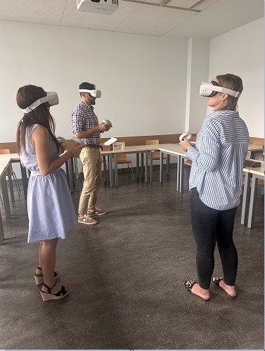 Dwie kobiety i mężczyzna w Sali wykładowej KSSiP pozują w goglach VR. 