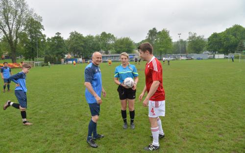Zdjęcie nr 5: trzech mężczyzn, jeden chłopiec i jedna kobieta na murawie piłkarskiej, kobieta trzyma piłkę do gry w piłkę nożną
