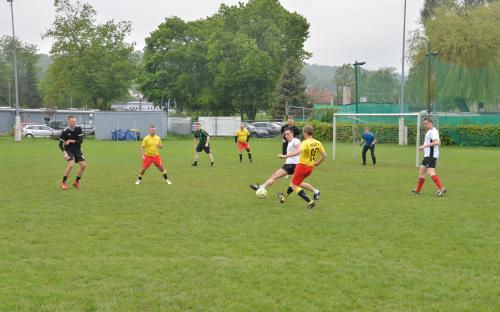 Zdjęcie nr 9: dziewięciu mężczyzn na boisku piłkarskim biegnących za piłką w czasie meczu piłki nożnej
