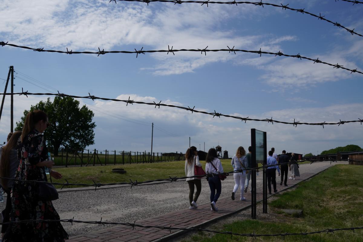 Uczestnicy wymiany podczas zwiedzania byłego obozu koncentracyjnego na Majdanku na pierwszym planie kolczaste ogrodzenie 
