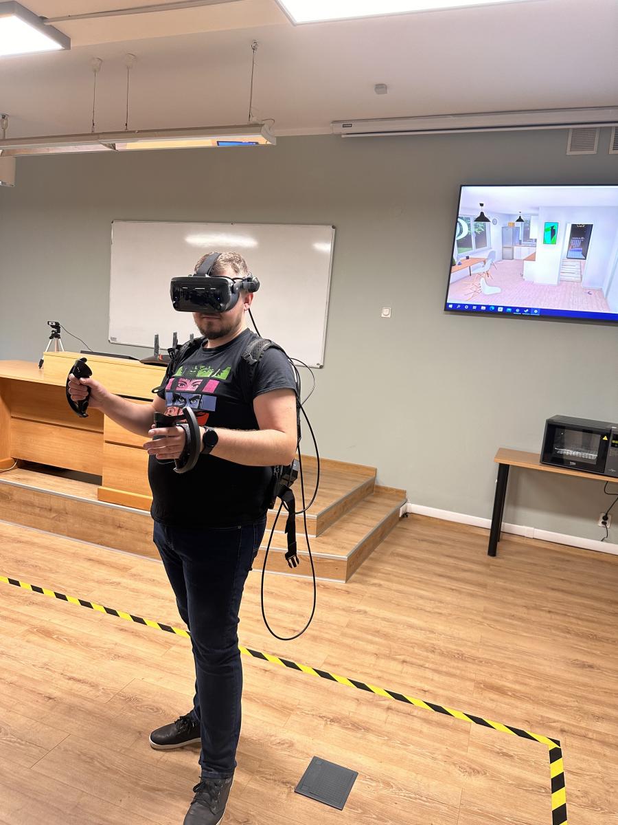 Zdjęcie nr 2 – mężczyzna testujący zastosowanie gogli VR