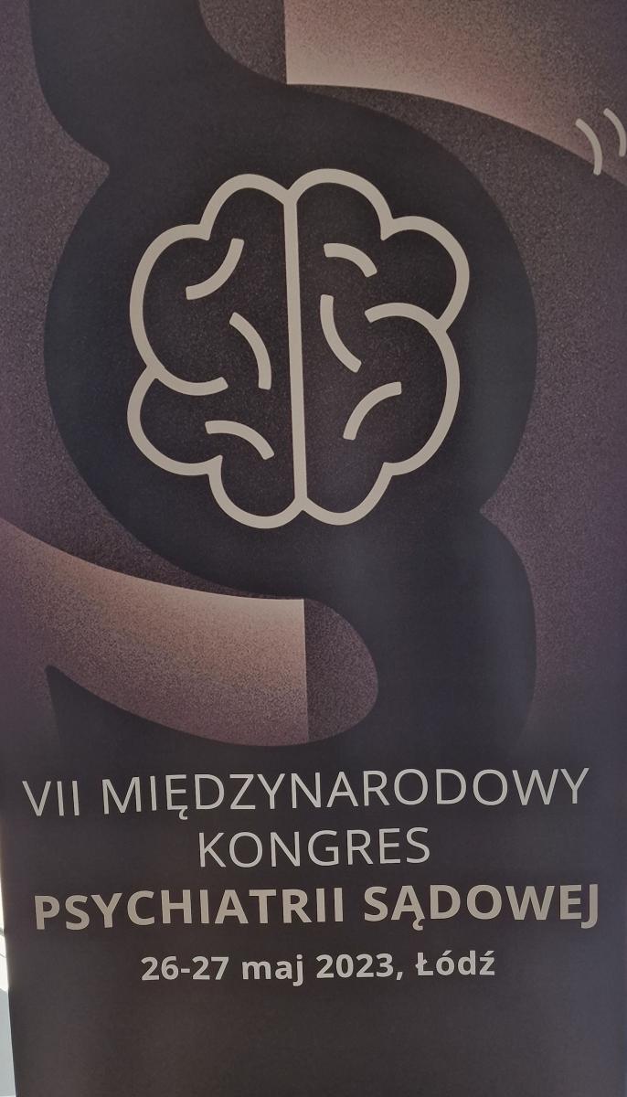 Baner VII Kongresu Psychiatrii Sądowej , przedstawiający kontur mózgu na brązowym tle ze znakiem paragrafu. 